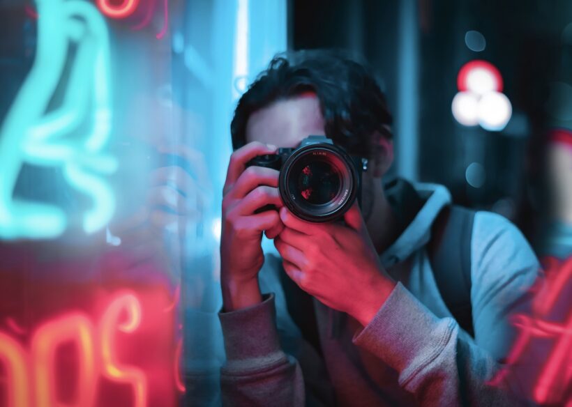 Photo of a Man Using a Black Camera